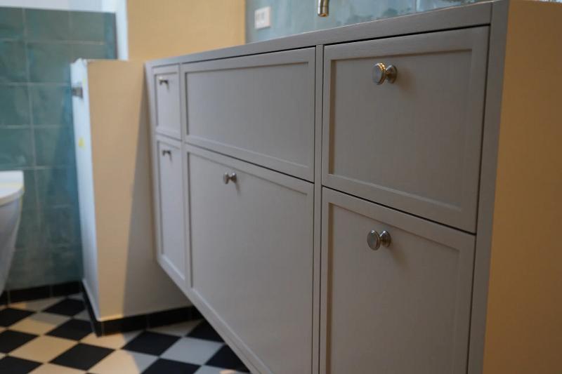 Grey vanity with green tile bathroom